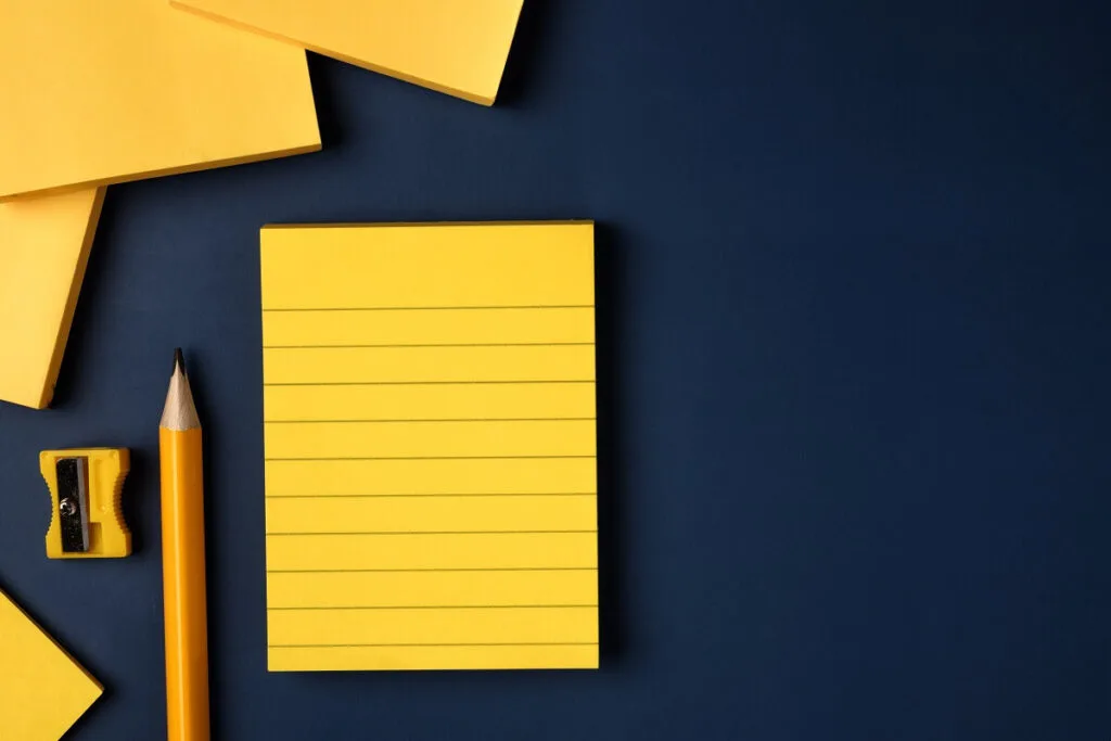 blank yellow sticky note and pencil on navy blue t 2022 12 16 10 05 00 utc