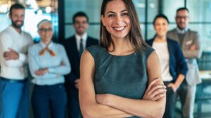 Best Job Search Sites for Executives. Diverse team of smiling executive professionals standing in a modern office, representing leadership and career success for executive job seekers.